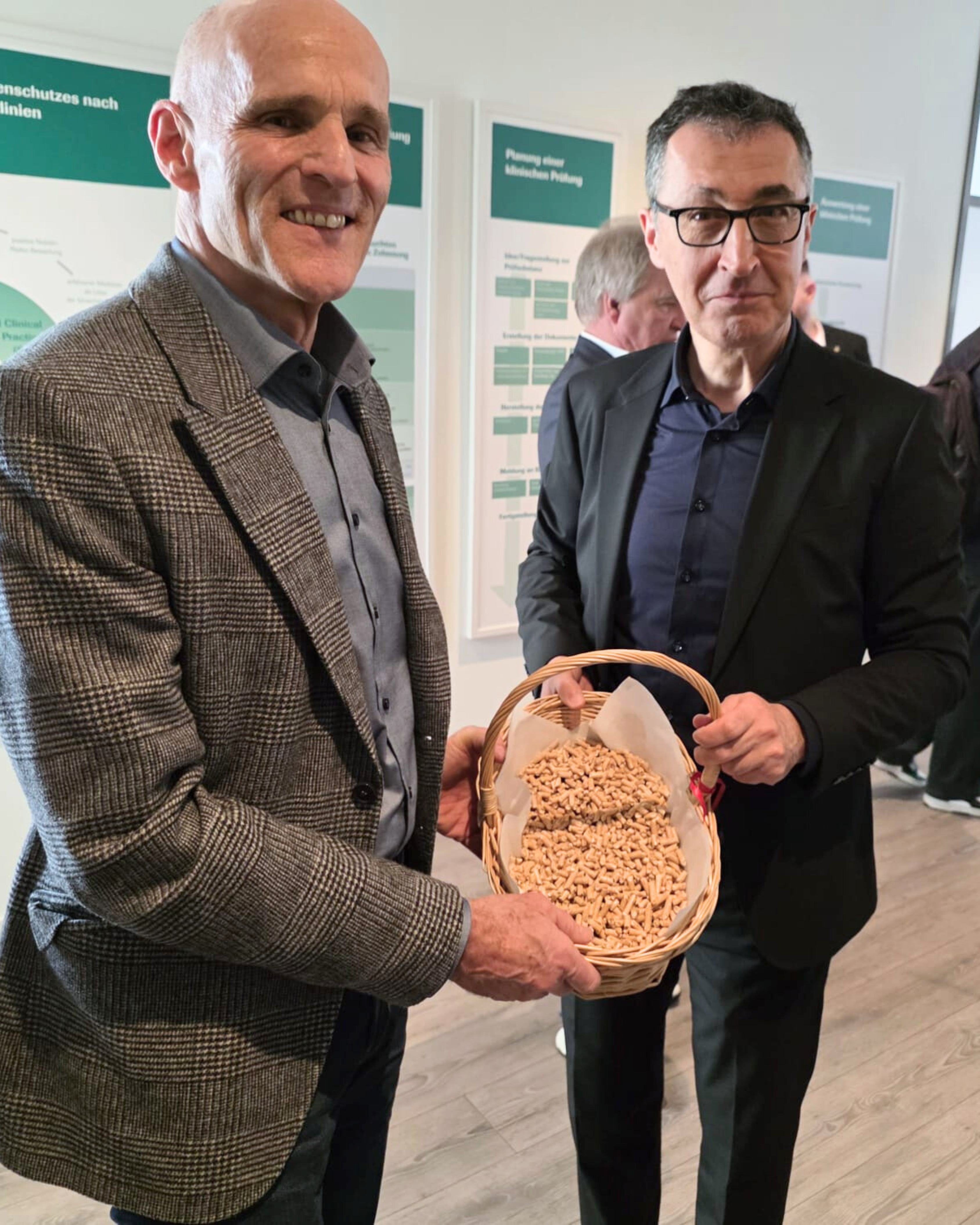 Helmut SChellinger (links) und Cem Özdemir (rechts) halten einen Korb mit Pellets gefüllt