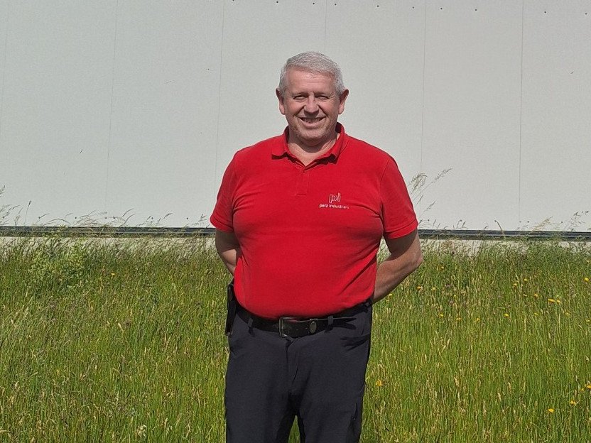 Porträt Reiner Wicklein vor einem Gebäude auf einer Wiese