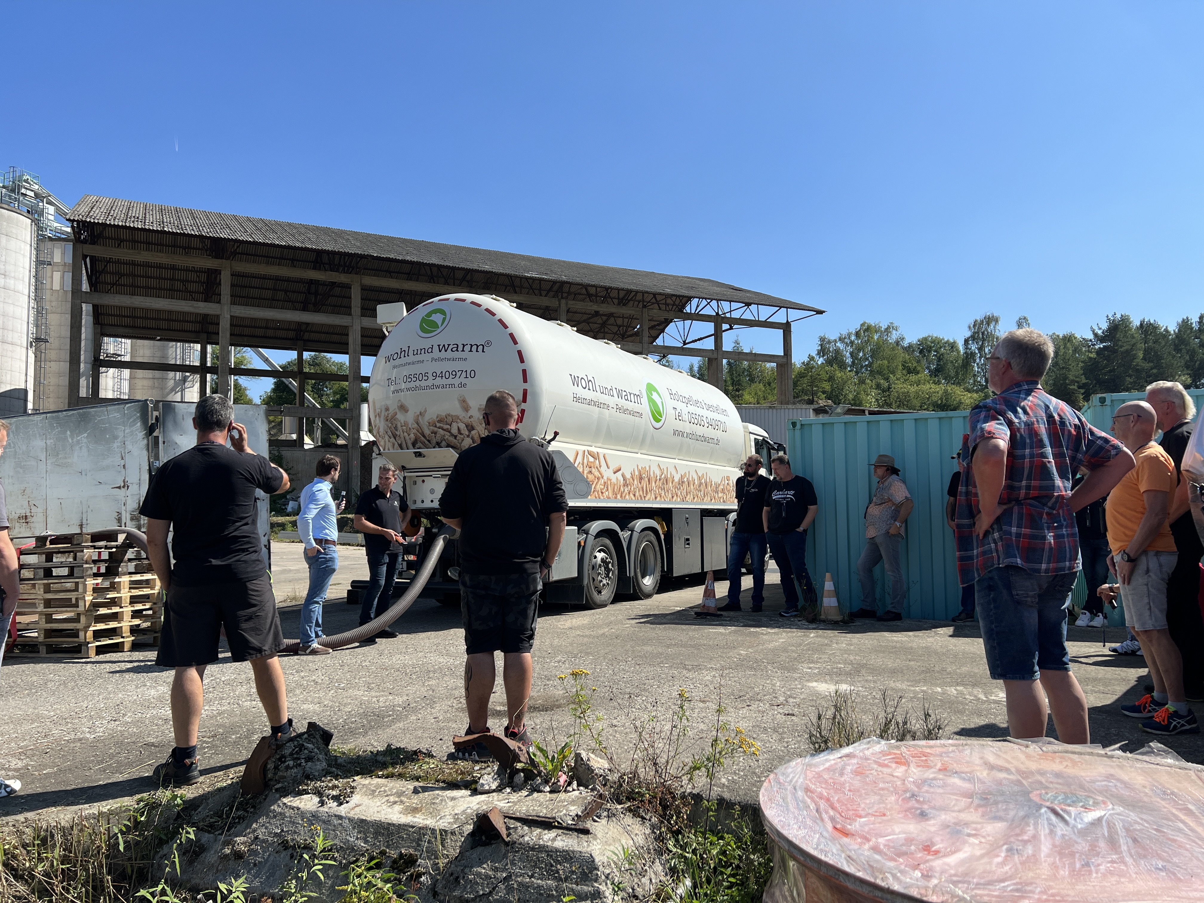 Mehrer Männer von hinten vor einem weißen LKW.
