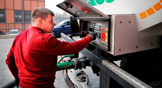 Indem er die richtigen Knöpfen am LKW drückt, bläst der Fahrer Pellets ins Pelletlager ein.