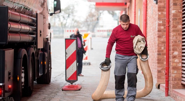 Der Pelletfahrer verbindet den Schlauch mit dem LKW und den Befüllstutzen am Pelletlager – so können die Presslinge problemlos eingeblasen werden.