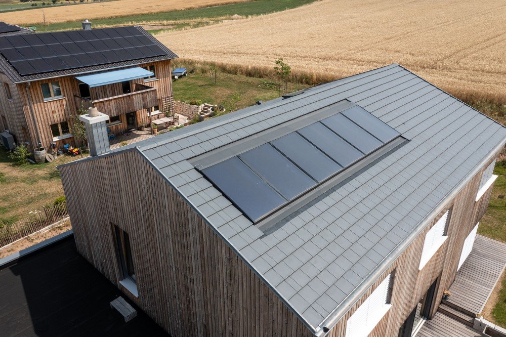 Es ist ein Holzhaus mit Solaranlagen auf dem Dach zusehen.