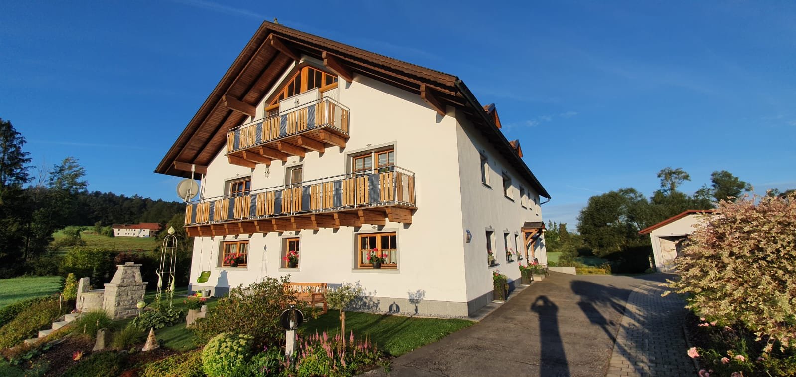 Ein mehrstöckiges Wohnhaus und davor einen Garten.